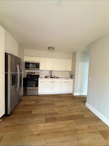 a view of a kitchen with a sink refrigerator and a window