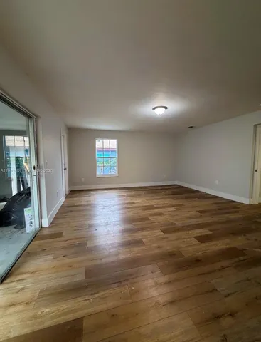 a view of wooden floor and windows in an empty room