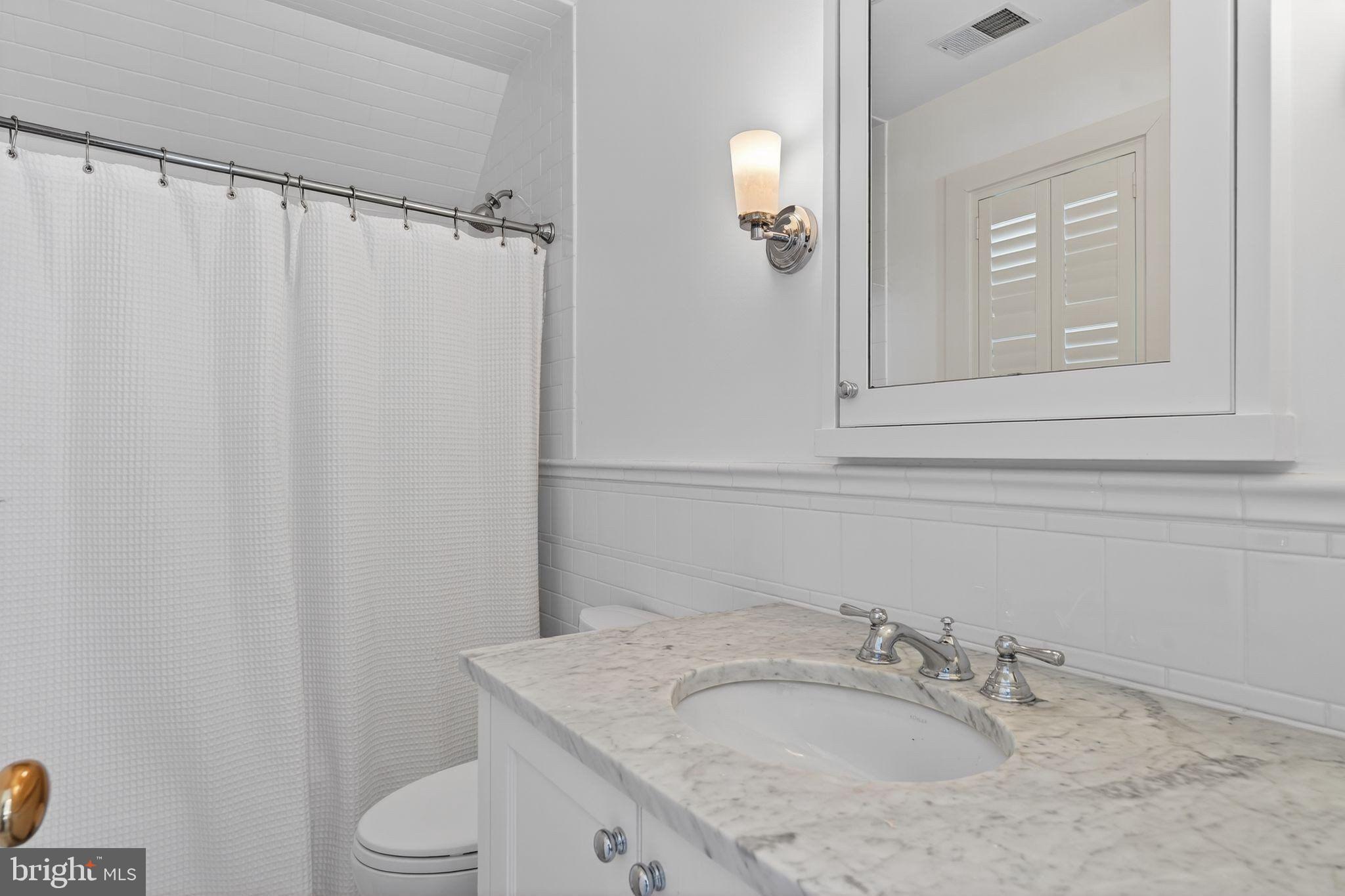 4340 Garfield Street Northwest Washington, DC 20007 - Photo 30 of 42 a bathroom with a granite countertop sink vanity mirror and toilet