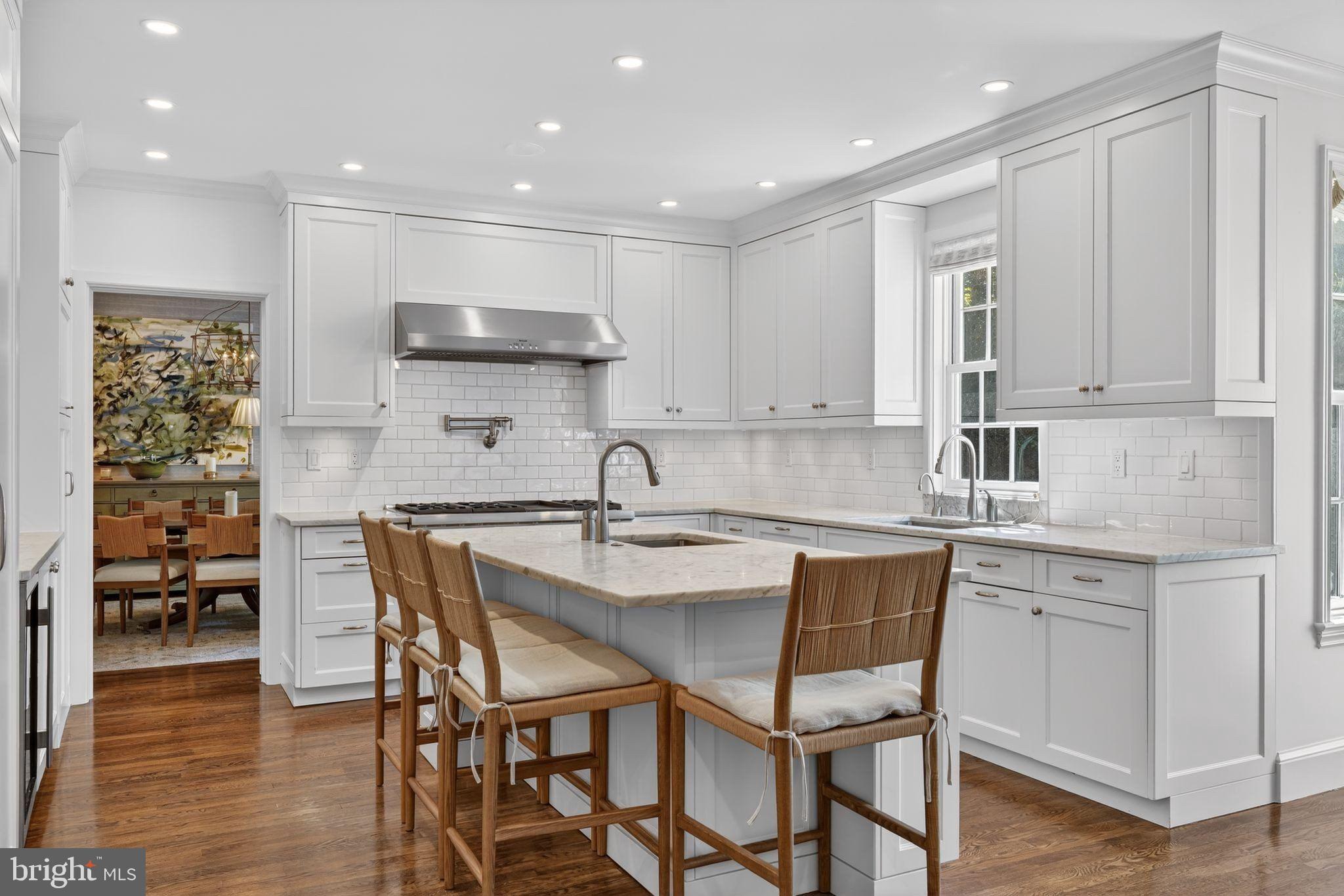 4340 Garfield Street Northwest Washington, DC 20007 - Photo 9 of 42 a kitchen with stainless steel appliances granite countertop a table chairs sink and cabinets
