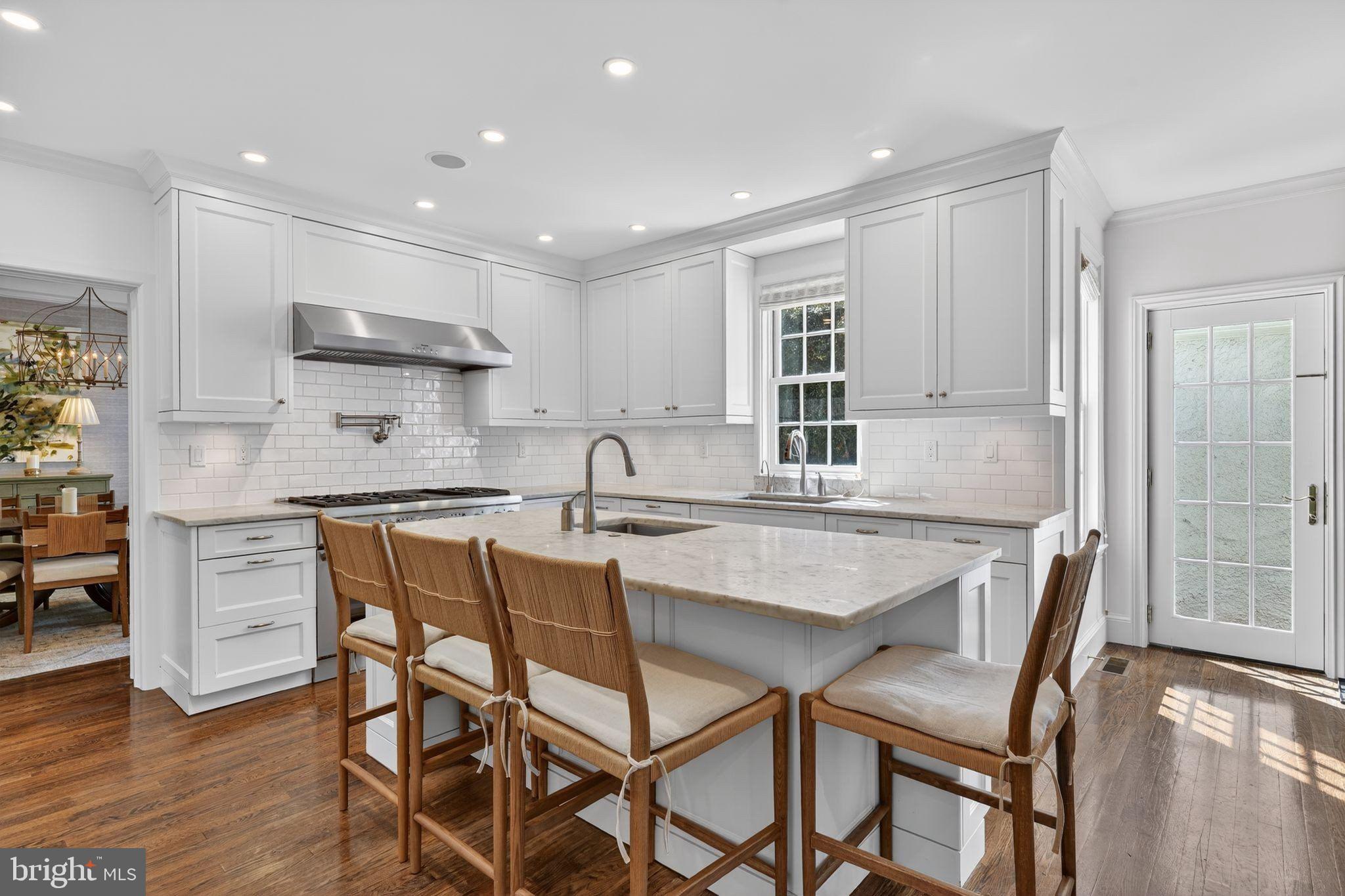 4340 Garfield Street Northwest Washington, DC 20007 - Photo 10 of 42 a kitchen with stainless steel appliances granite countertop a table chairs sink refrigerator and cabinets