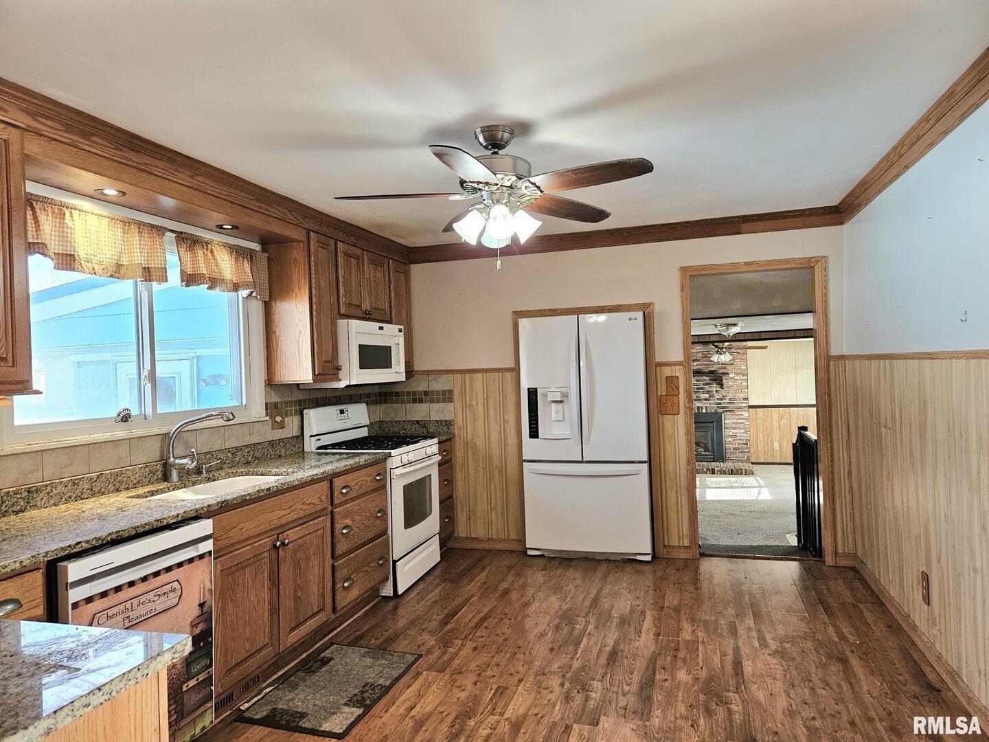 313 East 3rd Street Wilton, IA 52778 - Photo 13 of 14 a kitchen with granite countertop a refrigerator stove top oven and sink