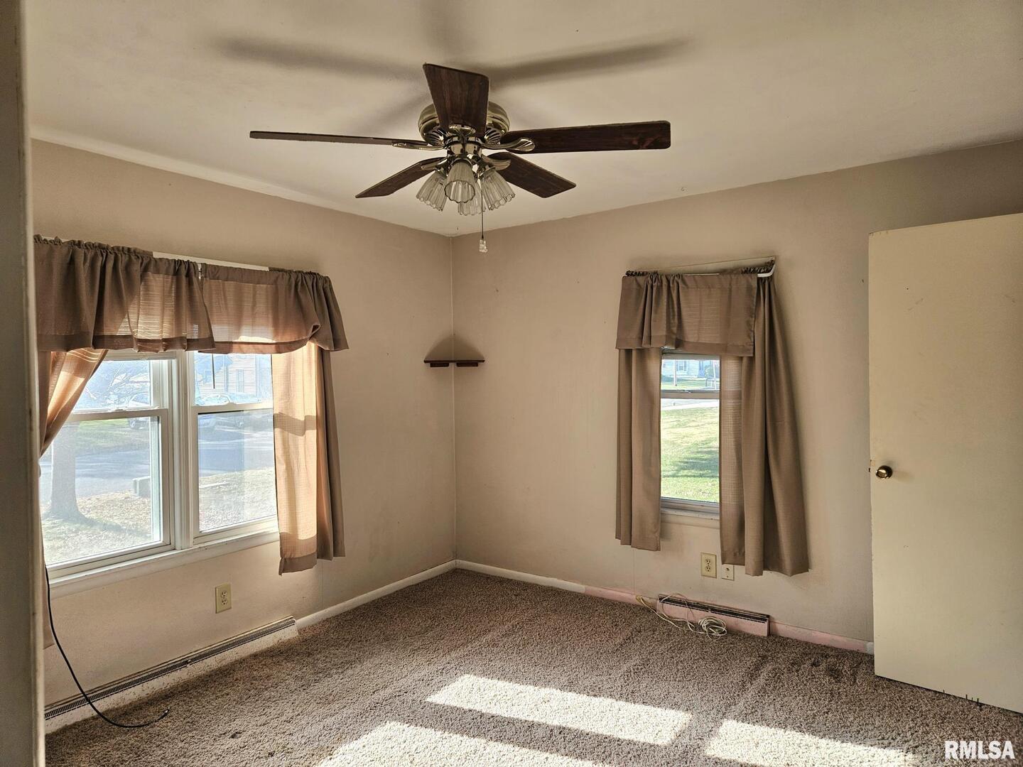 313 East 3rd Street Wilton, IA 52778 - Photo 10 of 14 an empty room with windows and fan