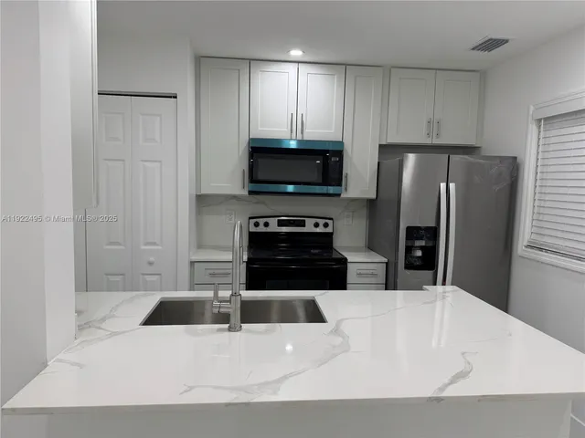 a kitchen with a refrigerator a stove a microwave and cabinets