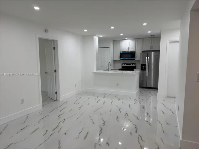a view of kitchen with refrigerator sink and stove