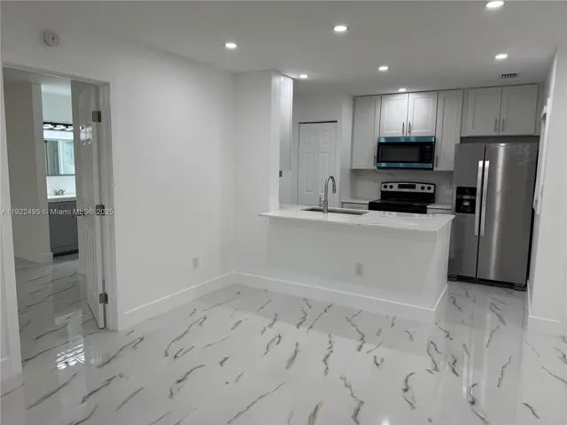 a kitchen with stainless steel appliances a refrigerator sink and microwave