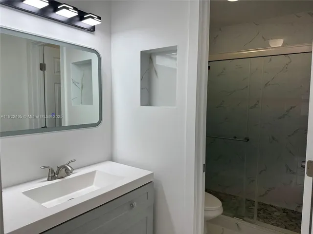 a bathroom with a sink toilet and shower