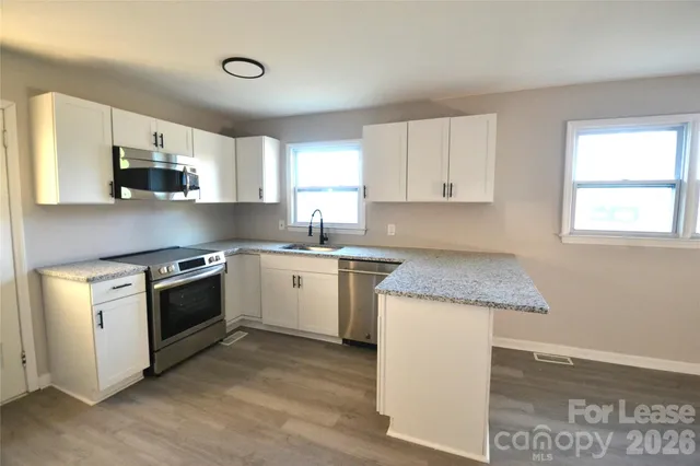 a kitchen with granite countertop white cabinets and white appliances