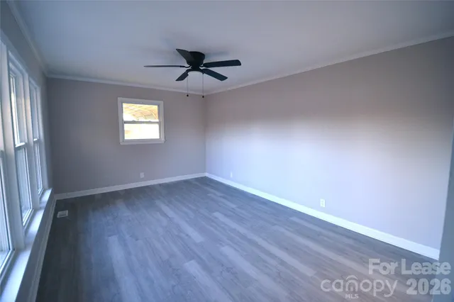 an empty room with a window and a ceiling fan