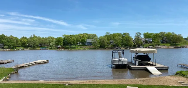 a lake view with boat and trees in the background