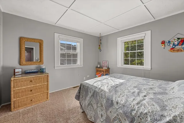 a bedroom with a bed and a dresser next to a window