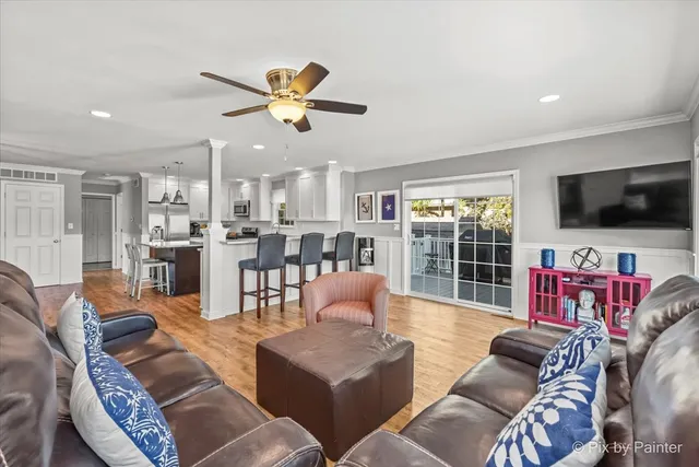 a living room with furniture kitchen view and a flat screen tv