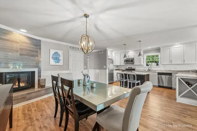a view of a dining room with furniture a chandelier and wooden floor