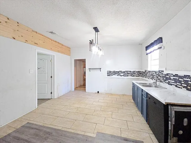 a large kitchen with granite countertop a sink and a stove