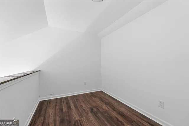 a view of a small space with wooden floor and a window