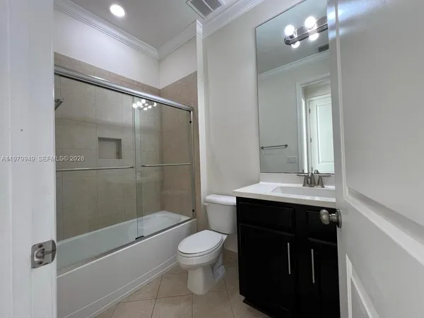 an empty room with wooden floor and mirror