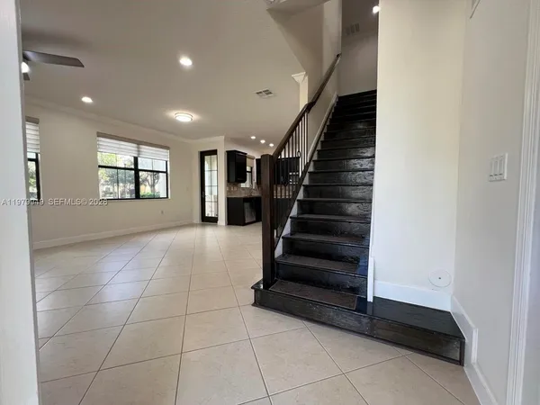 an empty room with windows and stairs