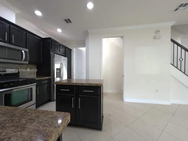 a kitchen with stainless steel appliances granite countertop a refrigerator and a stove top oven