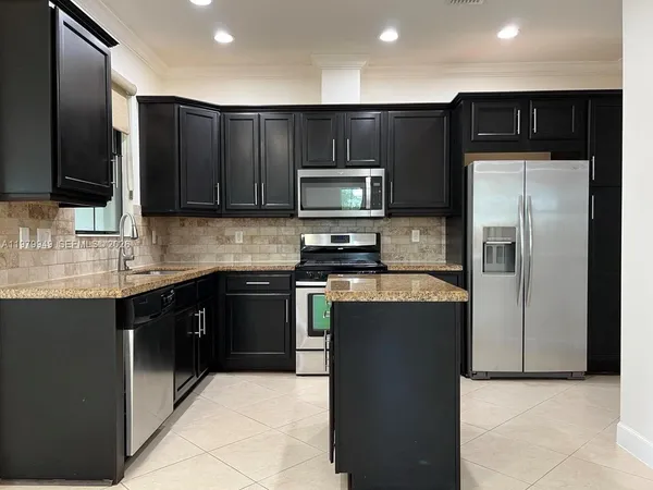 a kitchen with stainless steel appliances wooden cabinets and granite counter tops