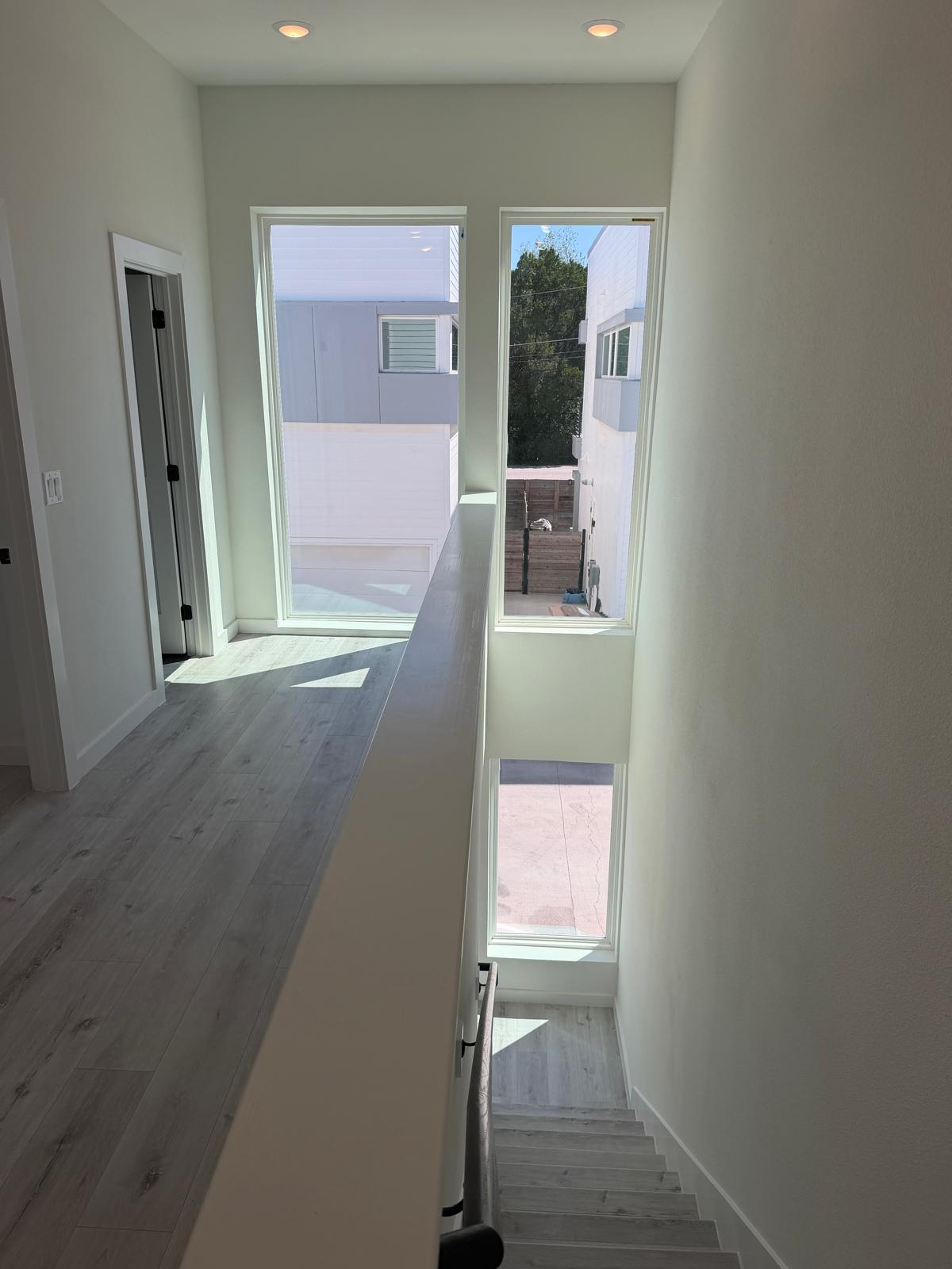 2000 Riverside Farms Road, Unit 12101 Austin, TX 78741 - Photo 17 of 33 Clean architectural lines define this upper hallway overlooking the stairs through tall windows.
