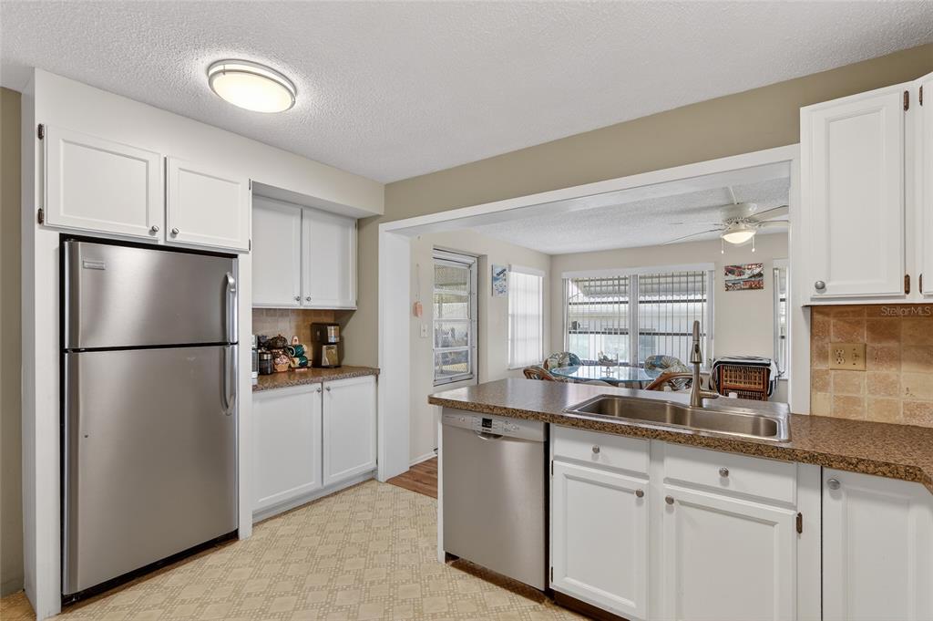 9238 140th Lane Seminole, FL 33776 - Photo 12 of 36 a kitchen with a refrigerator a sink and cabinets