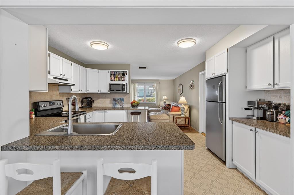 9238 140th Lane Seminole, FL 33776 - Photo 14 of 36 a kitchen with stainless steel appliances granite countertop a sink a stove and a refrigerator