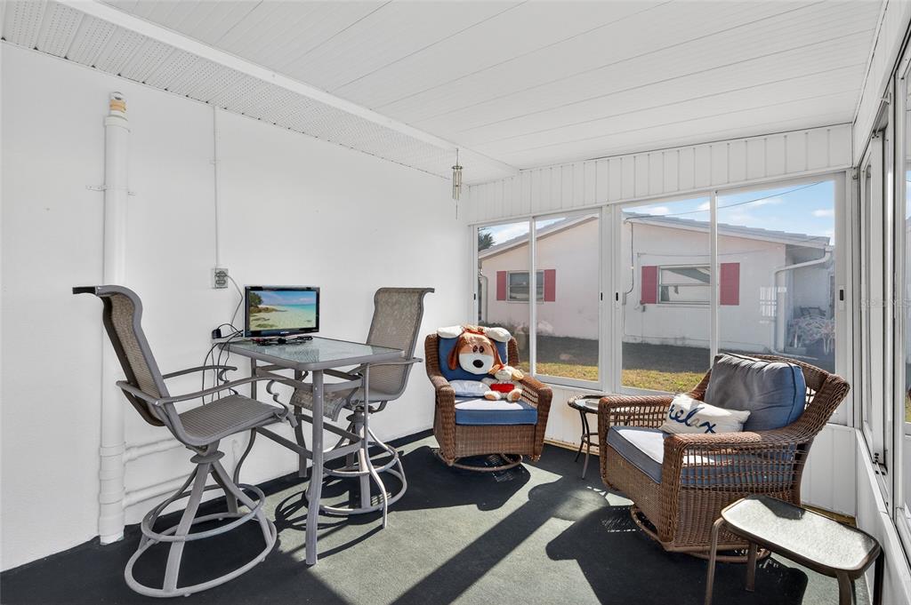 9238 140th Lane Seminole, FL 33776 - Photo 18 of 36 a living room with furniture a flat screen tv and a window