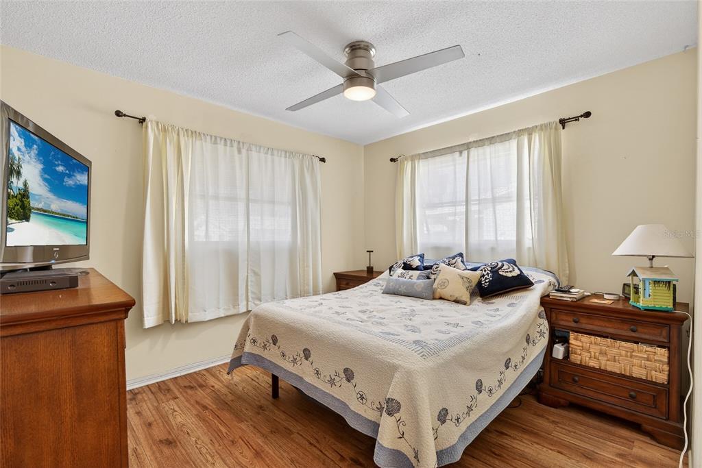 9238 140th Lane Seminole, FL 33776 - Photo 19 of 36 a bedroom with a bed and a flat screen tv