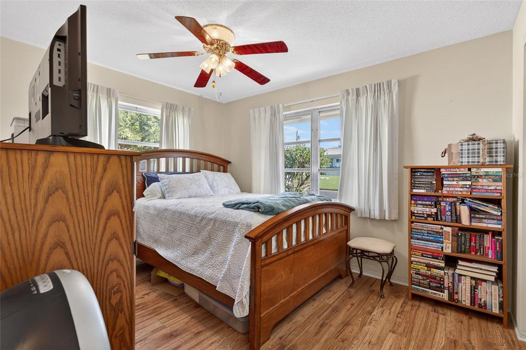 9238 140th Lane Seminole, FL 33776 - Photo 22 of 36 a bedroom with a bed bookshelf and a large window