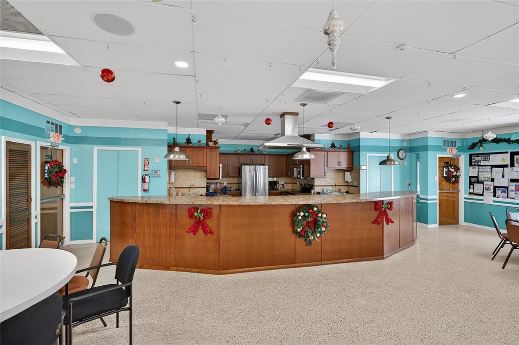 9238 140th Lane Seminole, FL 33776 - Photo 28 of 36 a kitchen with stainless steel appliances kitchen island granite countertop a sink and a refrigerator