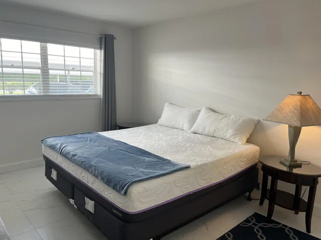 a bed sitting in a bedroom next to a window