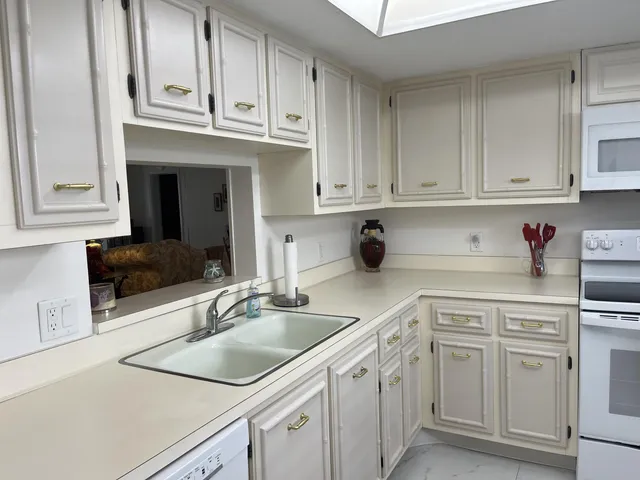 a kitchen with cabinets appliances a sink and a counter top