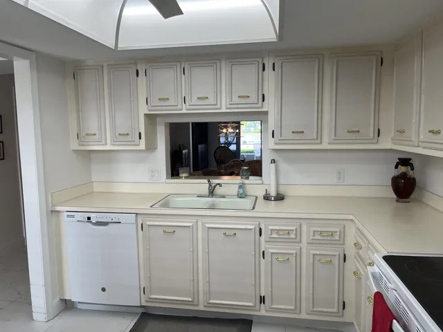 a kitchen with white cabinets and white appliances