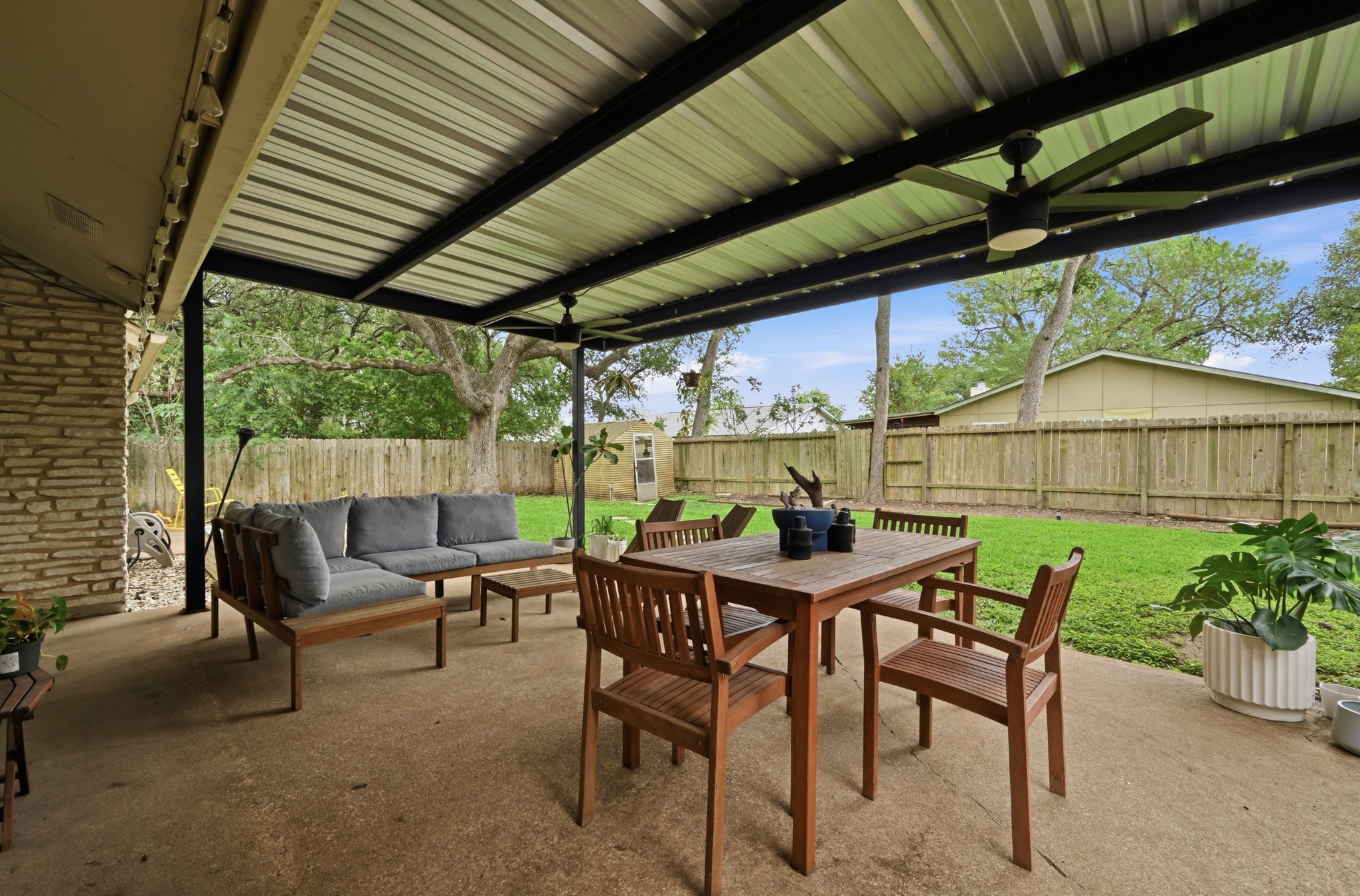 2509 Redleaf Lane Austin, TX 78745 - Photo 20 of 28 Expansive covered patio featuring a corrugated metal roof supported by black metal beams, concrete flooring, and ceiling fans