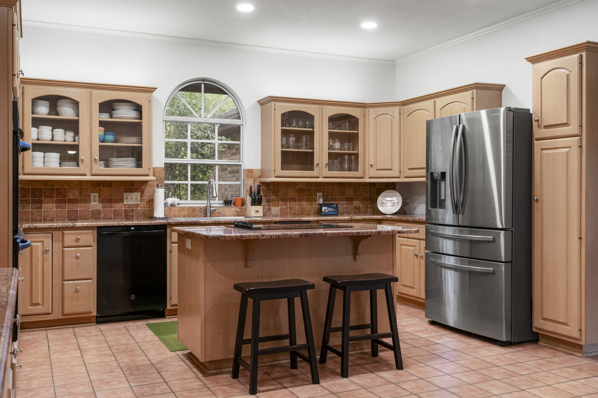 400 Hackberry Street Lockhart, TX 78644 - Photo 15 of 40 A well-appointed kitchen features a large window, ample cabinetry, and an island with bar seating.