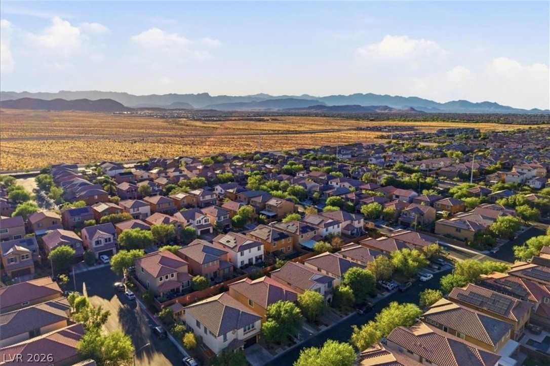 11009 Prairie Grove Road Las Vegas, NV 89179 - Photo 46 of 49 An aerial perspective reveals a vast residential community nestled against a sweeping desert landscape and distant mountains.