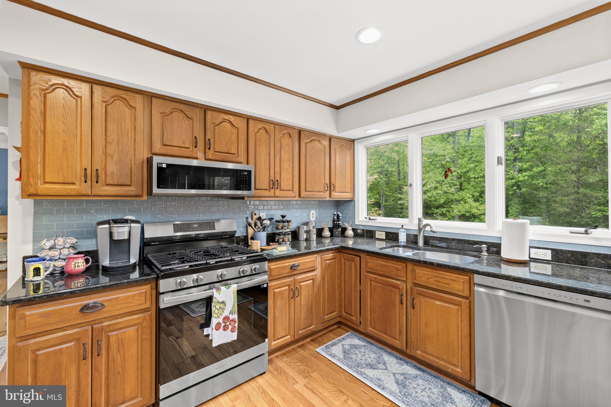 100 Boscobel Road Fredericksburg, VA 22405 - Photo 23 of 67 a kitchen with stainless steel appliances granite countertop a stove a sink and a microwave