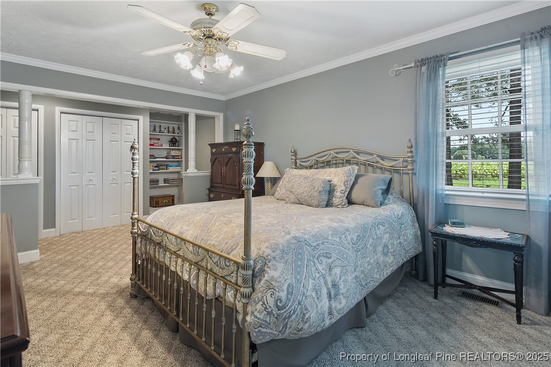 5017 Goldsboro Road Wade, NC 28395 - Photo 29 of 50 a bedroom with a bed a table and a chandelier