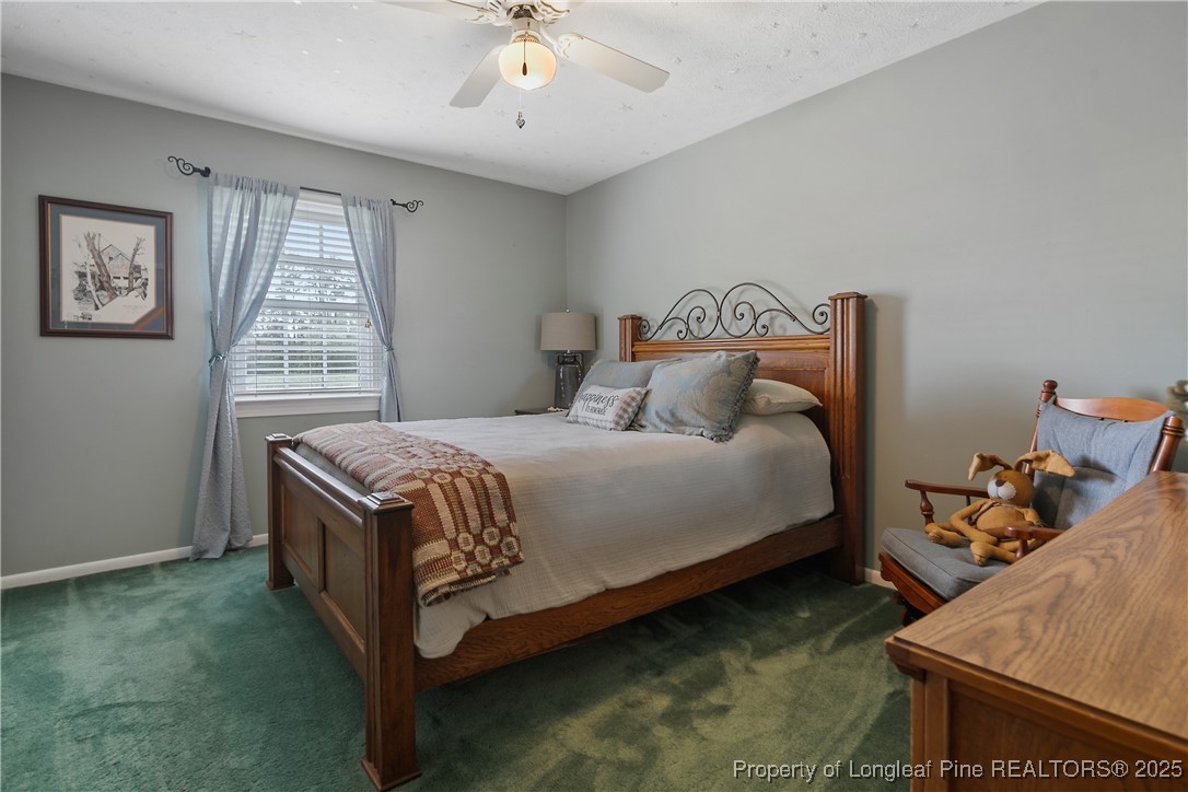 5017 Goldsboro Road Wade, NC 28395 - Photo 33 of 50 a bedroom with a bed and a chandelier