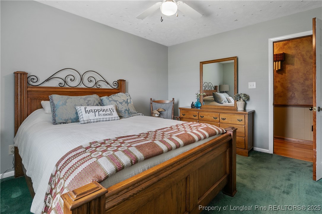 5017 Goldsboro Road Wade, NC 28395 - Photo 34 of 50 a bedroom with a bed and a chandelier