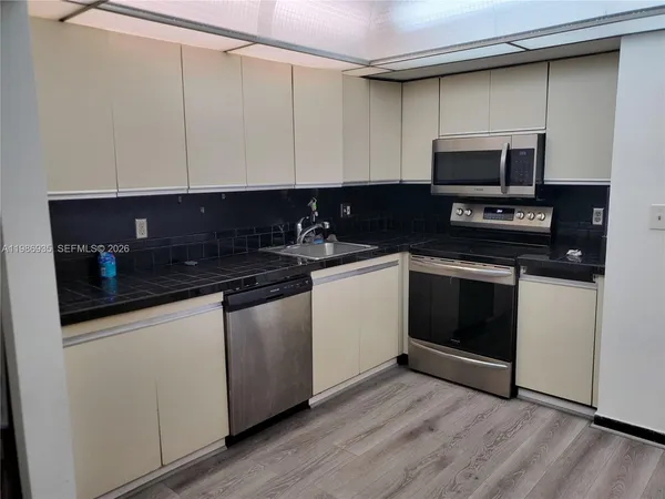 a kitchen with a sink and a stove top oven