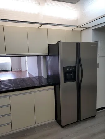a kitchen with cabinets and a refrigerator