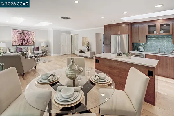 a dining room with furniture a kitchen view and wooden floor