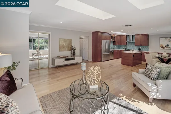 a living room with furniture kitchen view and a large window