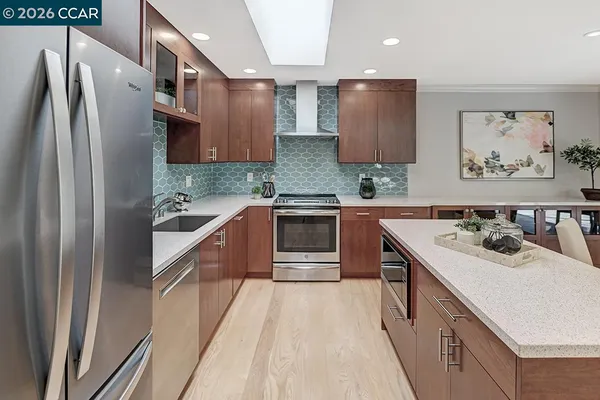 a kitchen with stainless steel appliances a sink stove and refrigerator