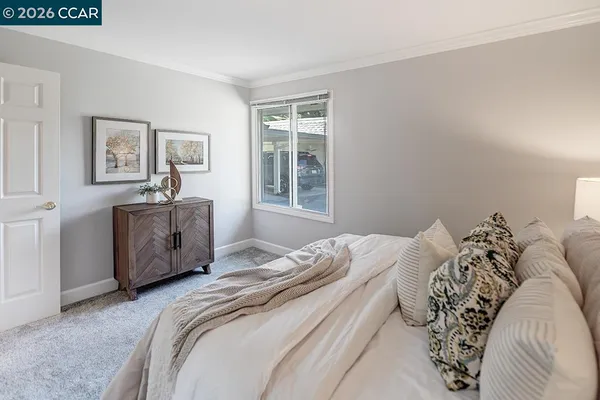 a spacious bedroom with a bed and a cabinets