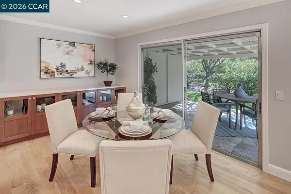 a dining room with furniture a large window and a rug