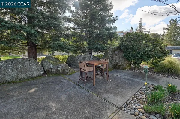 a front view of a house with a garden and tree