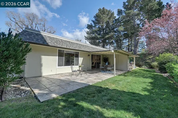 a view of a house with backyard and sitting area