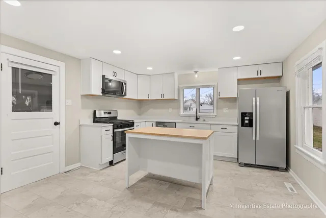 a kitchen with white cabinets and stainless steel appliances